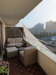 Custom-made waterproof shade sail installed on a modern balcony with rattan furniture.