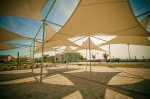 Toldo vela triangular de HDPE a medida en un entorno urbano moderno que protege del sol.