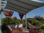 Vela ombreggiante premium impermeabile 3x2,5 m montata sopra una terrazza con mobili da giardino e amaca.