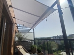 Vela ombreggiante premium impermeabile 3x4 m sul balcone, sospesa sopra un lettino e piante in vaso.