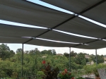 Γκρι αδιάβροχη λωρίδα κιόσκι 0,7x5m τοποθετημένη σε κατασκευή βεράντας πάνω από φυτά με θέα στο δάσος.