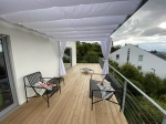 Store romain horizontal premium Decor 2,5x3 sur une terrasse moderne avec meubles de jardin et sol en bois.