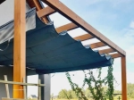 Store romain horizontal premium Decor de 2,5x3 m monté sous une pergola en bois sur une terrasse.