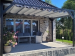 Γκρι οριζόντιο ρωμαϊκό στόρι premium Decor σε κατασκευή βεράντας πάνω από έπιπλα κήπου και πρόσοψη από ελαφρύ τούβλο.