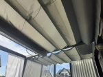Οριζόντιο ρωμαϊκό στόρι premium Decor 2,5x3 σε γκρι χρώμα, τοποθετημένο σε κατασκευή μοντέρνας πέργκολας.