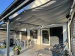Waterproof retractable shade sail 3x3 in grey, installed over a modern terrace with garden furniture.