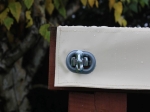 Metalen draaisluiting voor het bevestigen van de witte PVC-bekleding van een terrasoverkapping op maat.