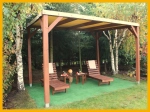 PVC terrasoverkapping voor het hele jaar op maat boven een houten pergola met ligstoelen in de tuin.