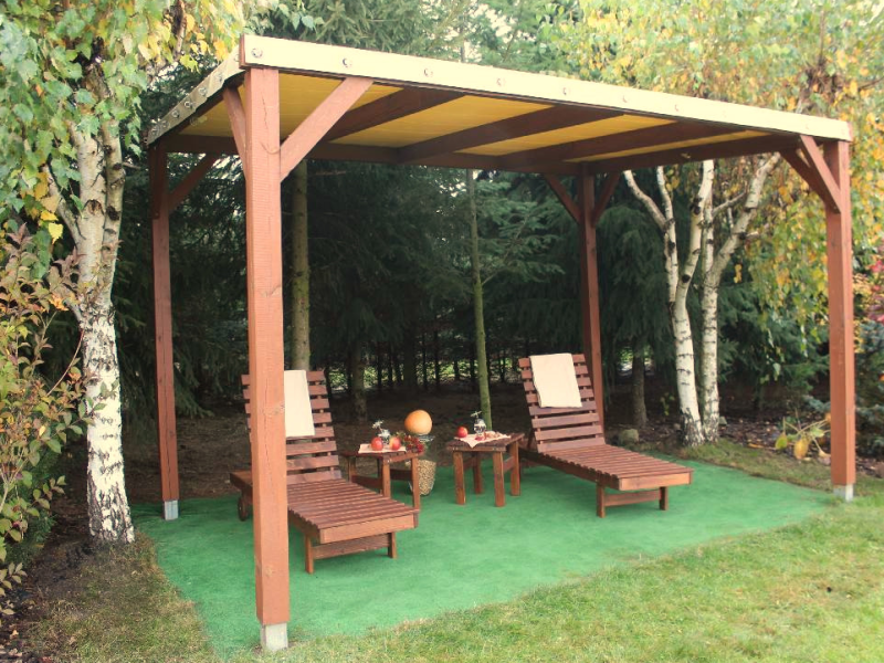 PVC terrasoverkapping op maat voor het hele jaar over een houten pergola met ligbedden op een groene ondergrond.