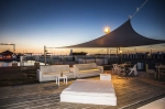 Vela de sombra premium impermeável 1,4x1,4x2 m montada sobre um terraço com móveis de exterior brancos ao pôr do sol.