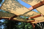 Lichtbruine HDPE zonneschermstrook voor prieel, 0,4x5 m, gemonteerd op een houten pergolaconstructie.