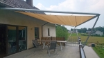 Custom-made HDPE sun sail protecting the terrace from the sun, mounted on a metal structure.