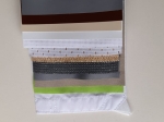 Samples of professional roller blind fabrics in various colours, weaves and textures, arranged in a cascade.