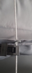 Tope gris para cable de acero montado en la tela de un toldo vela o estor plegable.