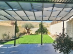 Αδιάβροχη φάσα κιόσκι 0,4x5m πλεγμένη σε μοντέρνα κατασκευή στέγαστρου βεράντας σε κήπο με γκαζόν.