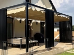 Store romain horizontal premium Decor 3x2,5 monté sur une pergola noire moderne au-dessus de la terrasse avec meubles.
