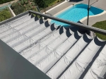 Store bâteau premium Decor gris horizontal au-dessus de la terrasse, avec piscine de jardin en arrière-plan.