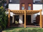 Horizontaal premium vouwgordijn Decor 3x5 in beige gemonteerd op een houten pergola-constructie.
