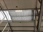 Waterproof retractable sail 1.5x5 m mounted under the glass roof of a hall structure.
