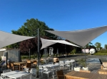 Vela ombreggiante triangolare bianca impermeabile premium 3x3x4,2 su una terrazza moderna con mobili da giardino.