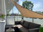 Beige waterdicht premium schaduwdoek 3,5x3,5x3,5 gemonteerd boven een hoekbank op een modern terras.