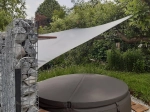 Velă de umbrire gri impermeabilă premium 3x4 m montată deasupra unei piscine rotunde lângă un gabion.