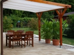 Vela de sombra retangular retrátil 3x5 m montada numa pérgula de madeira sobre um terraço com mobiliário.