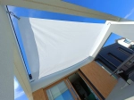 Pânză de umbrire dreptunghiulară albă, 3,2x4,2 m, montată deasupra terasei unei case moderne.