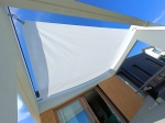 Pânză de umbrire albă cu dimensiuni de 4,2x5 m montată pe terasa unei case moderne sub cerul albastru.