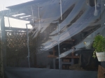 Прозрачно покривало за тераса по мярка със сив кант, монтирано на дървена беседка с изглед към градината.