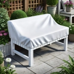 Housse de protection blanche sur mesure pour meubles de jardin, protégeant un banc blanc sur une terrasse parmi les plantes.