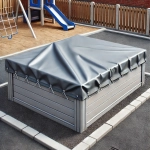 Siva ponjava po meri za zaščito peskovnika z lesenimi stranicami na otroškem igrišču.