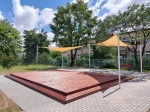 Vela ombreggiante triangolare beige HDPE 3x3x4,2 montata sopra una terrazza in legno in giardino.