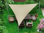Vela de sombra impermeável premium bege 1,4x1,4x2 sobre móveis de jardim em relvado verde.