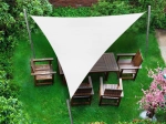 Vela de sombra triangular branca impermeável premium 4,2x4,2x5,9 m montada sobre um conjunto de móveis de jardim em madeira na relva.