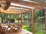 Wasserdichtes ausziehbares Sonnensegel 3x5 m auf einer Holzpergola über der Terrasse mit Möbeln und Hängematte.