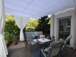 Store romain horizontal de terrasse premium Decor blanc, dimensions 2,5x3 m, installé au-dessus d'un salon de jardin.