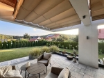 Οριζόντιο ρωμαϊκό στόρι premium Decor 2,5x3 που σκιάζει μια μοντέρνα βεράντα με έπιπλα κήπου και θέα στον κήπο.