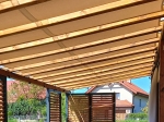 Bande de pavillon imperméable 0,4x5m montée sur une structure de pergola en bois dans un jardin.