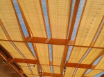 Bandă aurie de umbrit HDPE pentru foișor, 0,4x5 m, împletită printr-o structură de pergolă din lemn.