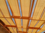 Gouden HDPE zonneband voor prieel, 0,4x5 m, gevlochten door een houten pergolaconstructie.