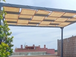 HDPE zonnedoek 0,7x5m gemonteerd op de metalen constructie van een pergola op het terras.