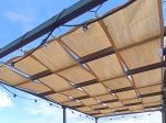 HDPE sunshade strip for gazebos, 0.7x5 m, stretched on a modern pergola structure with lighting.