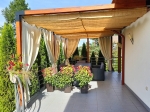 Ahşap pergola üzerine modern teras çatısı olarak monte edilmiş özel ölçü yatay HDPE Roma stor güneşlik.