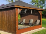 Skaidrus terasos uždangalas rudi kraštais ant pavėsinės su pagal užsakymą pagamintais lauko baldais.