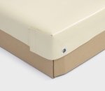 Corner of a custom-made cream PVC tarpaulin attached to the side panel of a car trailer.