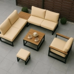 Móveis de jardim elegantes com almofadas creme e mesa de madeira - ideais para proteção com uma capa de almofada.