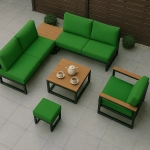 Conjunto de móveis de jardim verde com capas de almofada resistentes, mesa de centro e puff num terraço.