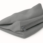 Housse de coussin de jardin en tissu gris avec fermeture éclair métallique apparente.