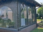 Personalised terrace tarpaulin with stone-imitation print and transparent windows, mounted on a gazebo.